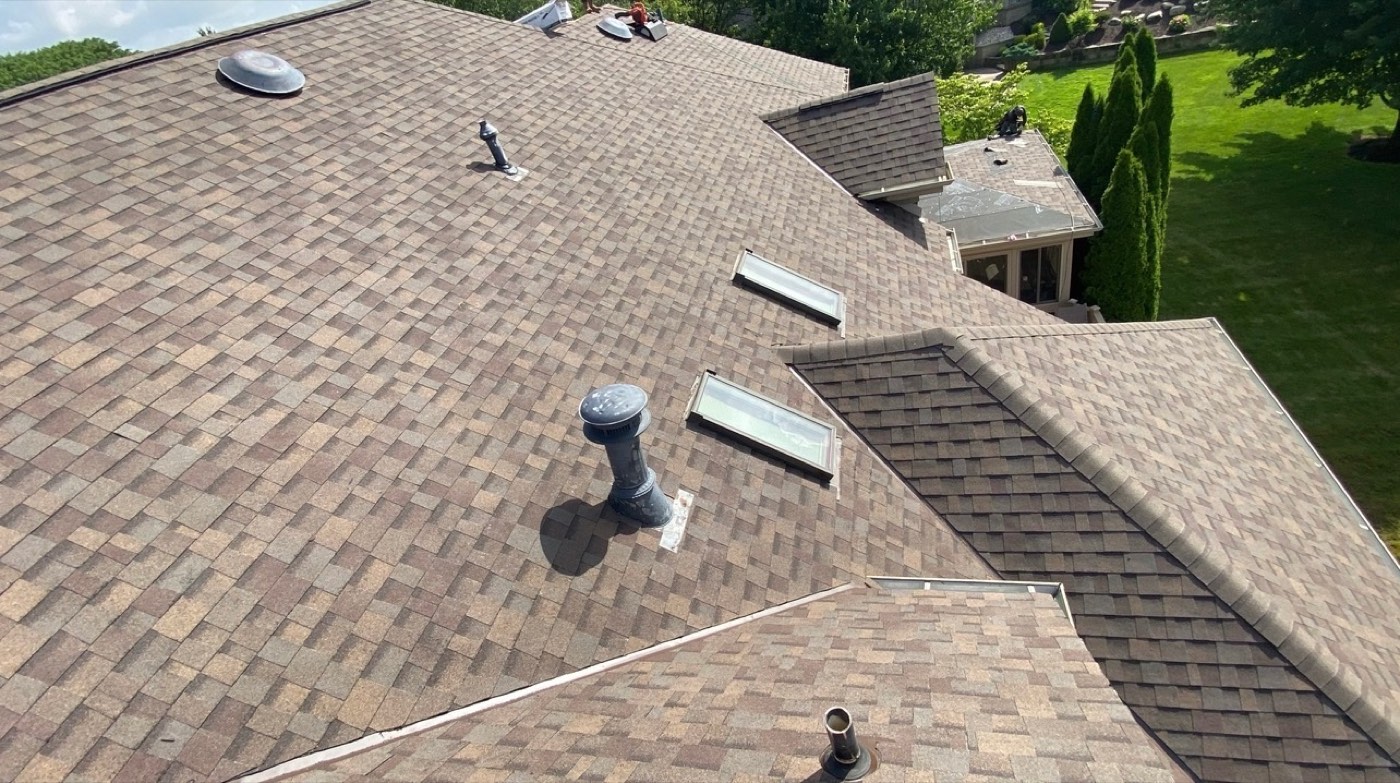 Aerial view of a brown blend shingle roof with new skylights and vents