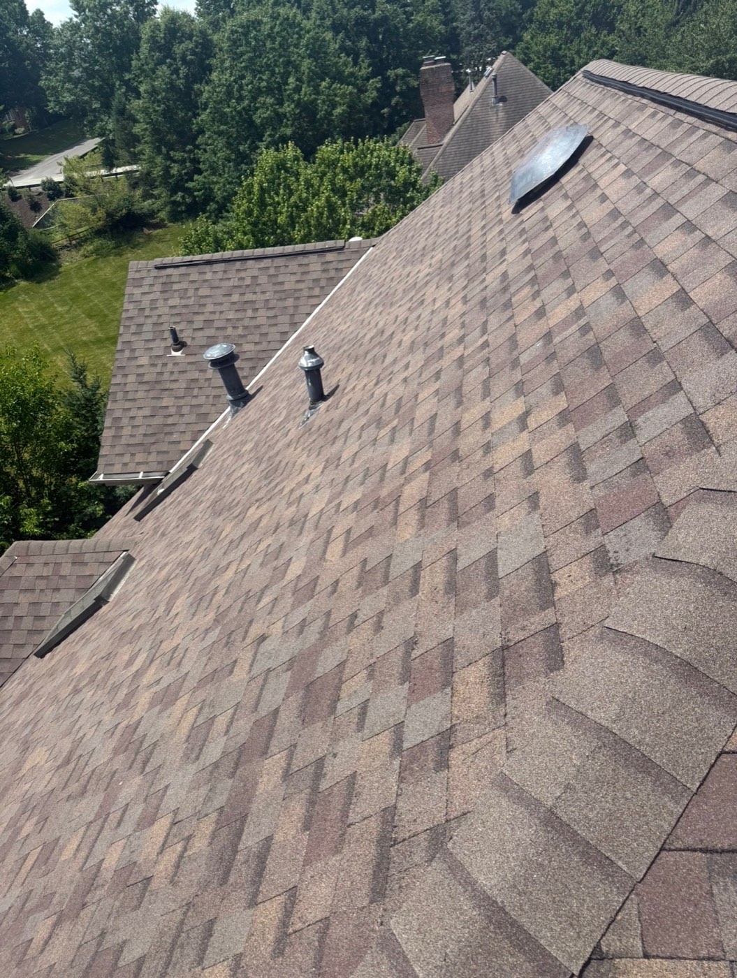 Brown blend shingle slope with new roof vents