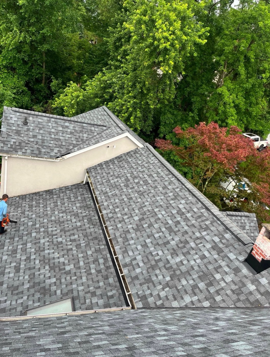 New gray blend shingle roof with clean valleys on a stucco home