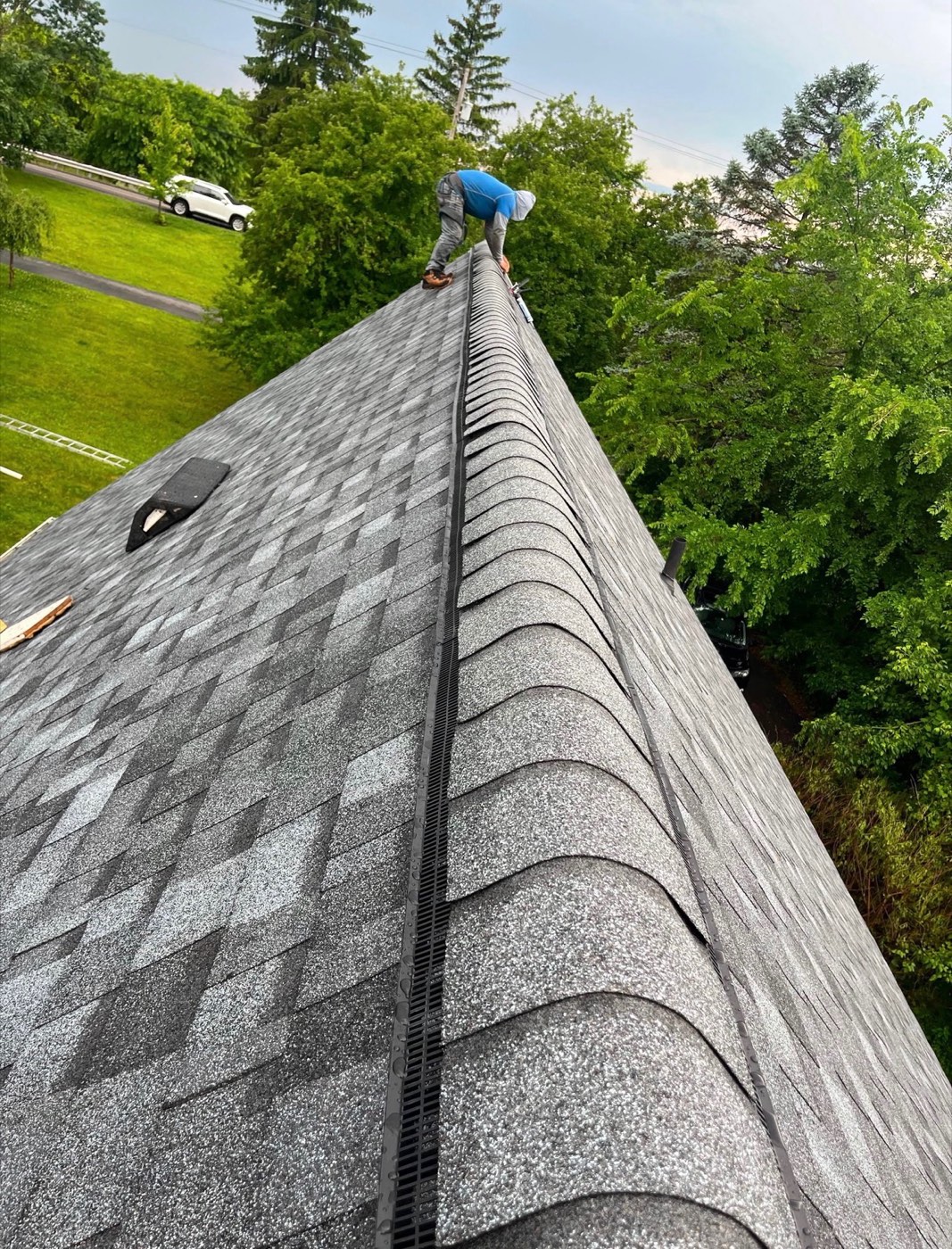 Ridge vent installed along the peak of a new gray shingle roof