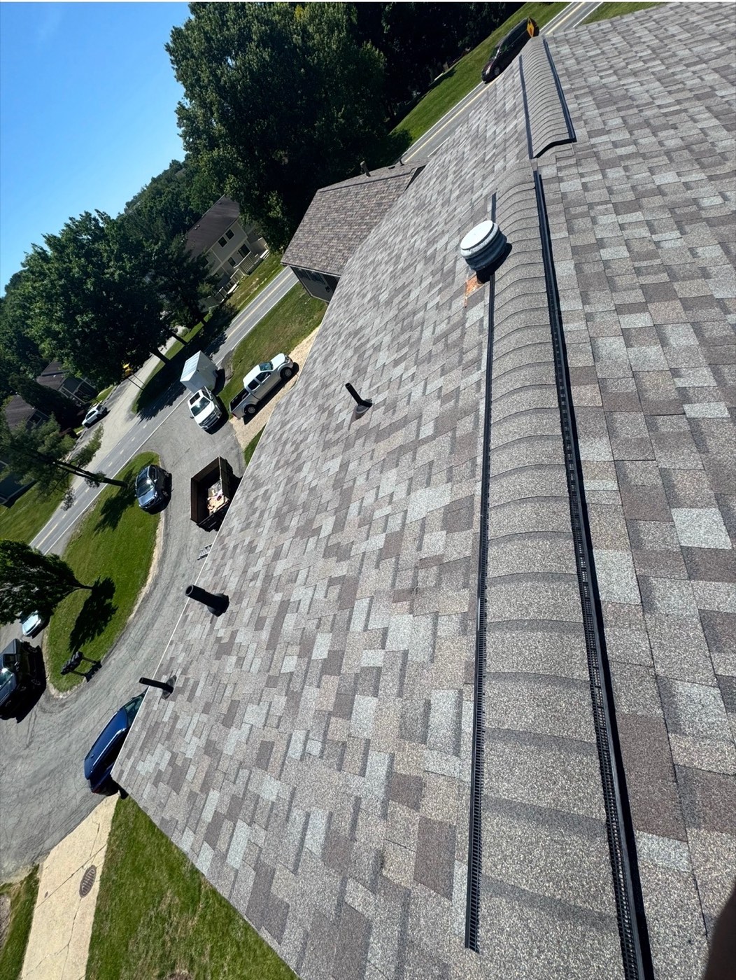 Completed tan blend shingle roof with ridge vent
