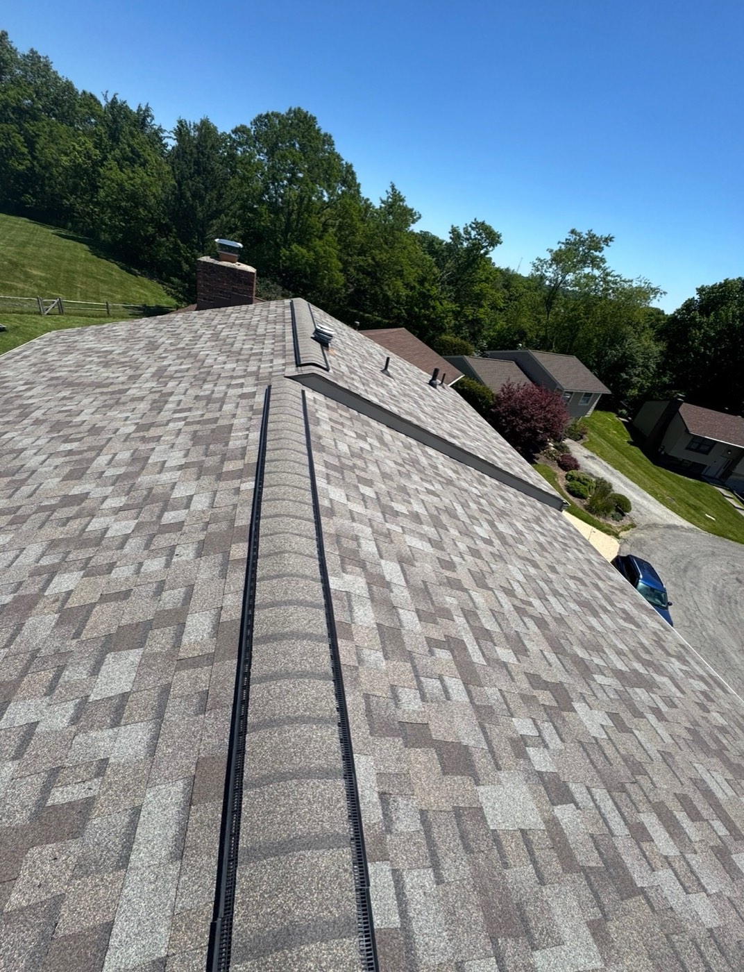 New tan blend shingle roof overlooking a hillside neighborhood