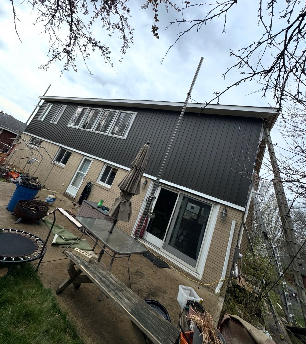 New dark vertical siding on a home's rear upper story