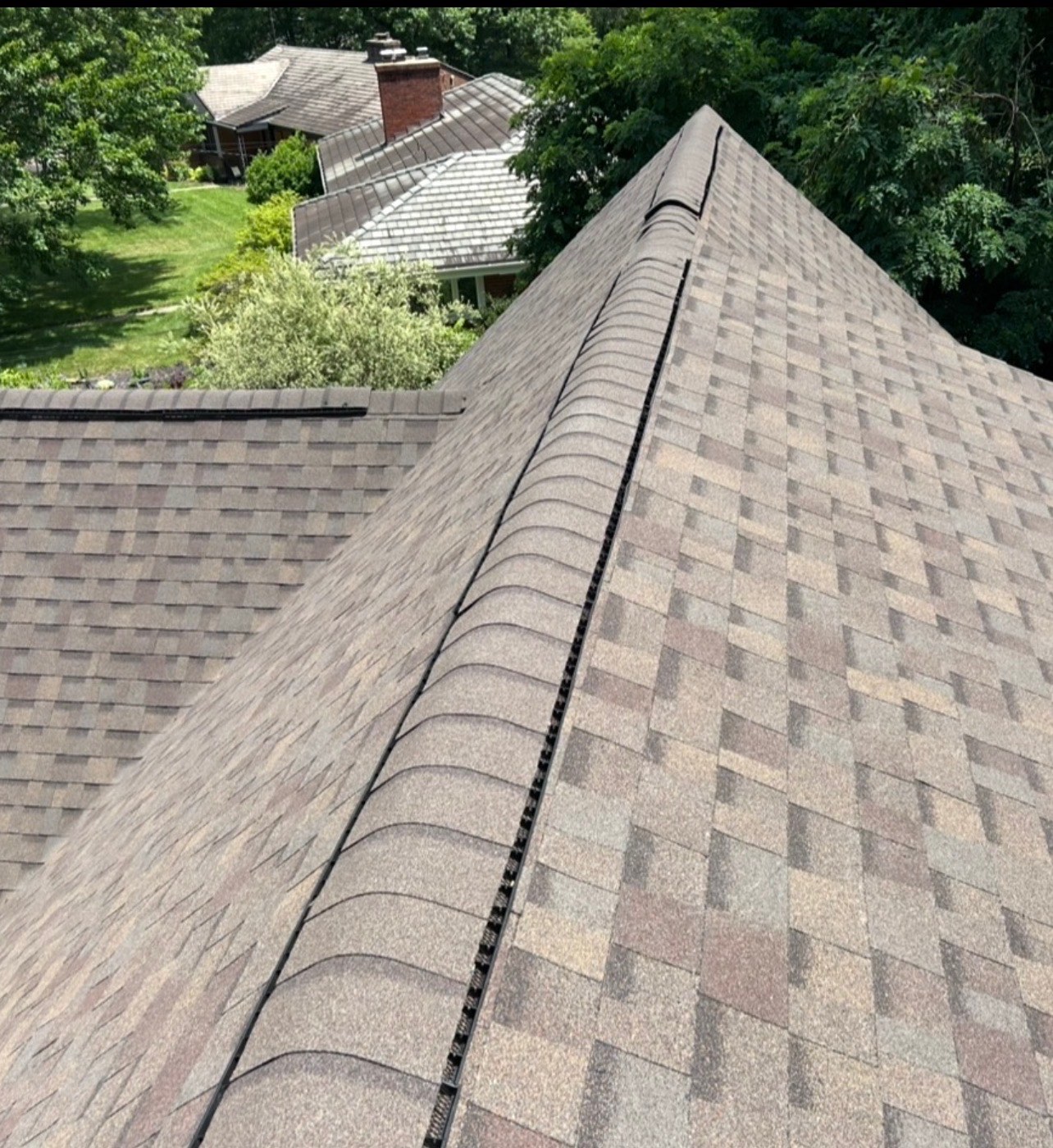 New ridge caps on a brown blend hip roof